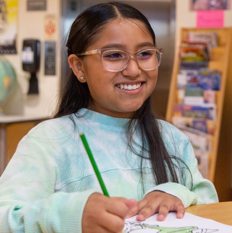 Girl wearing glasses and painting.